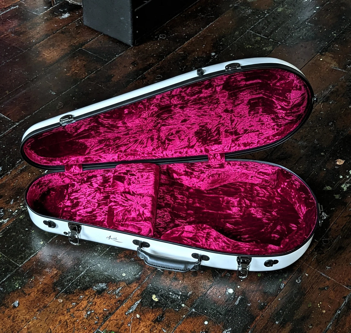 Airloom Tura case open, showing the Pinot Red crushed velvet interior and storage compartment lid
