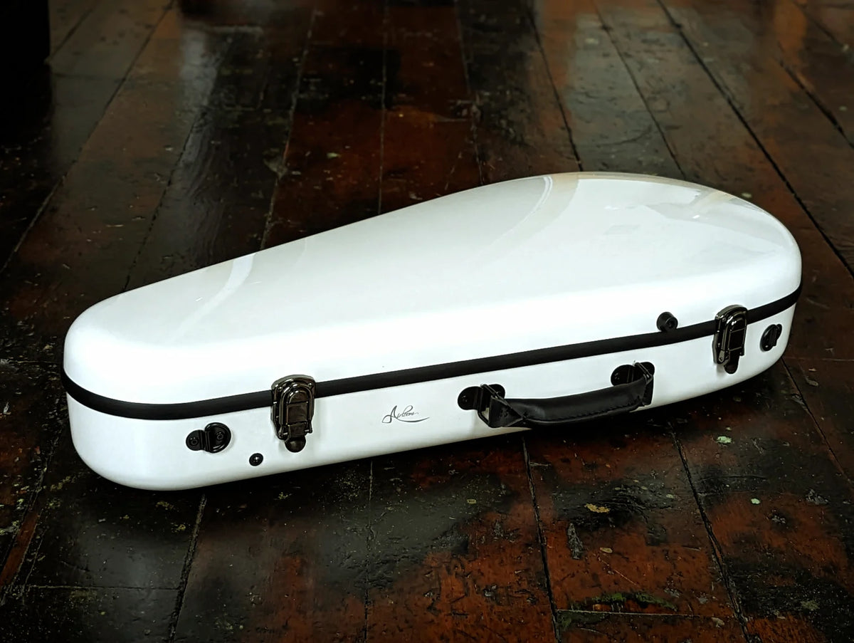 Gloss white Airloom Tura carbon fiber mandolin case closed on a wood floor, showing latches and leather handle