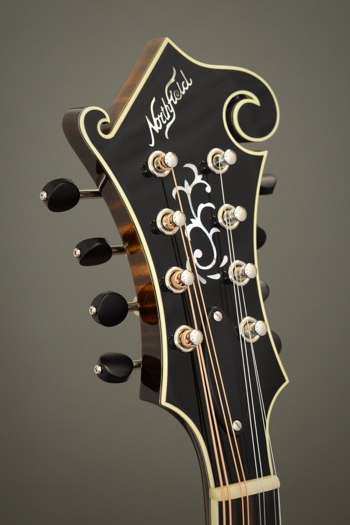 Headstock of the Northfield Big Mon mandolin with the Northfield logo and scroll inlay