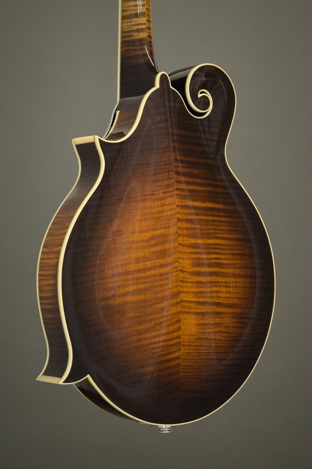 Flame maple back of the Big Mon mandolin, angled view with the scroll