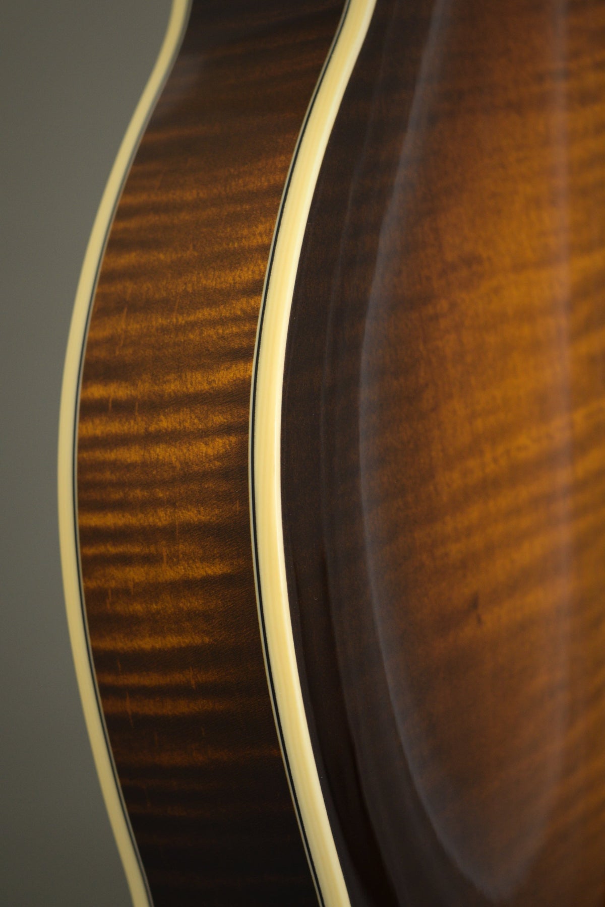 Flame maple rim and binding along the Big Mon mandolin's body curve