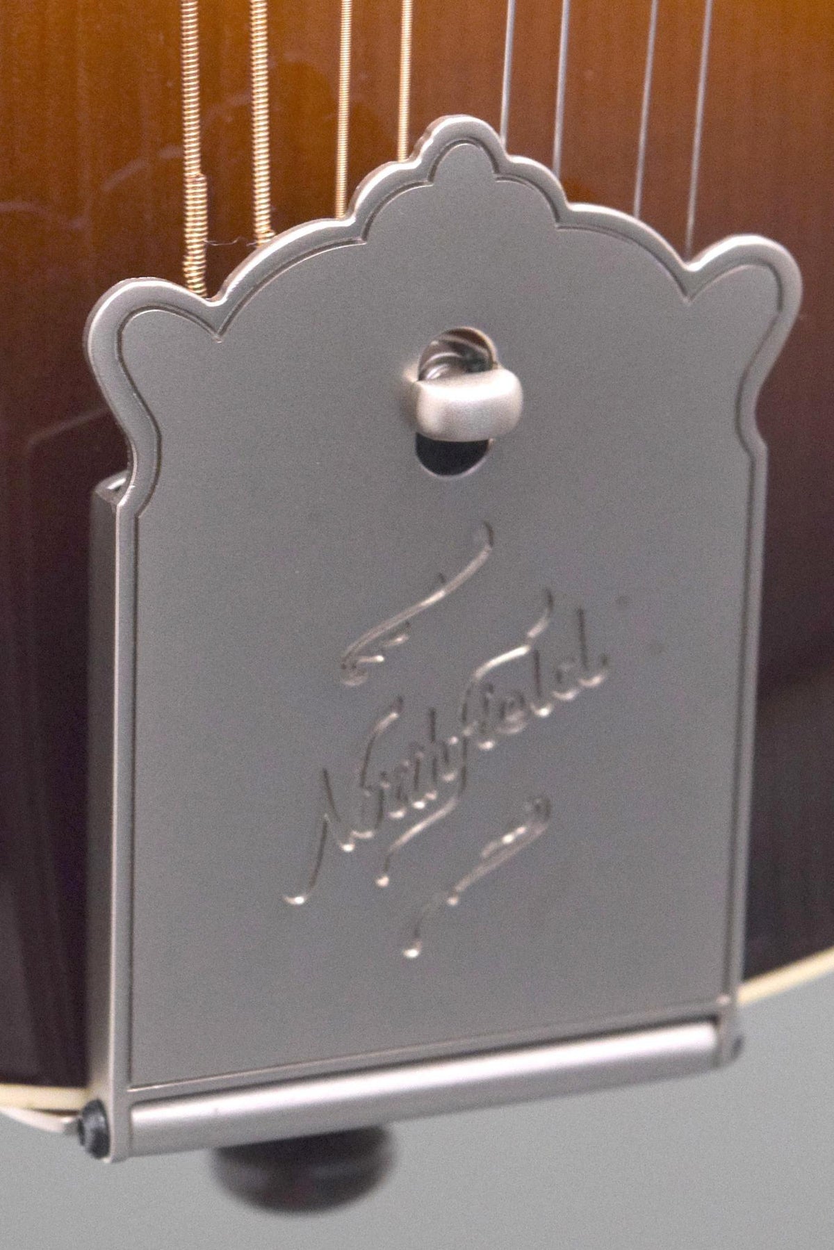 Close-up of the Big Mon tailpiece cover showing the two small finish spots noted in the listing
