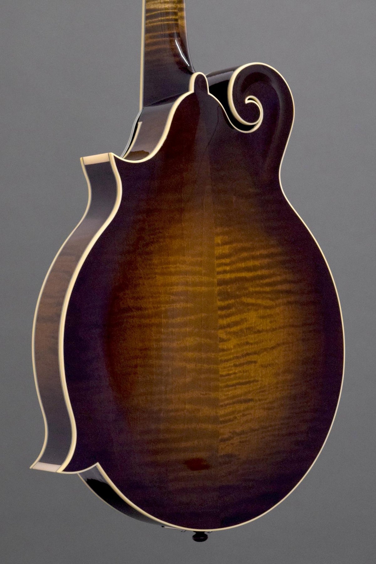 Flame maple back of the Big Mon mandolin, angled view with the scroll