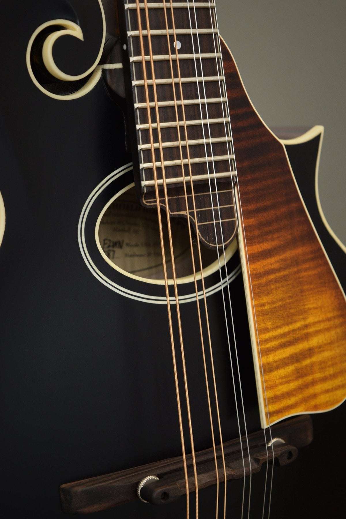 Oval sound hole, flame maple pickguard, and ebony bridge on the F2S mandolin