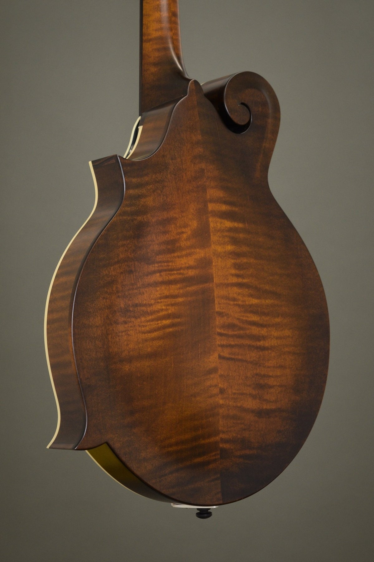 Flame maple back of the F5S mandolin, angled view with the scroll